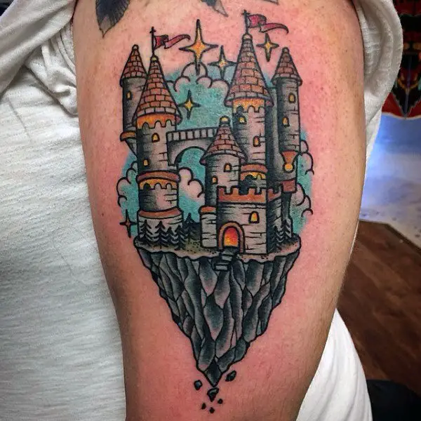 colorful-castle-on-crumbling-cliff-mens-bicep-tattoo