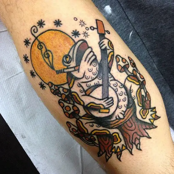 old-school-mens-bicep-sun-tattoo-with-frog-playing-musical-instrument