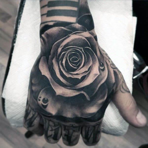 detailed-mens-hand-tattoo-of-black-ink-rose-flower-with-water-droplet