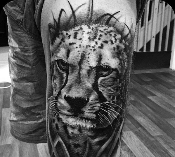 thigh-male-cheetah-in-grass-tattoo-with-black-and-grey-ink-design