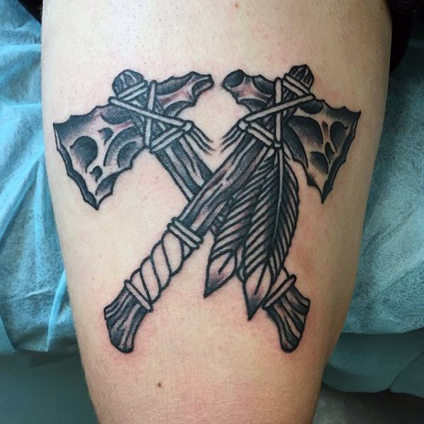black-ink-outlined-tomahawk-guys-tattoo-on-thigh