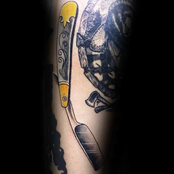 grey-straight-razor-with-yellow-pattern-tattoo-male-forearms