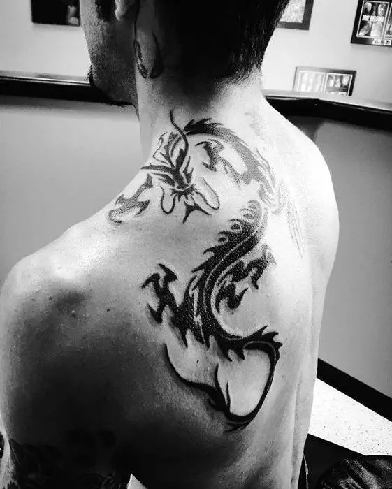 back-of-shoulder-guys-black-ink-tribal-dragon-tattoo-inspiration