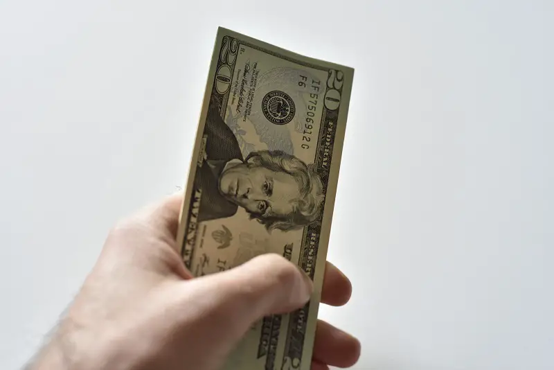 twenty-dollar-bills-in-hand-with-white-background