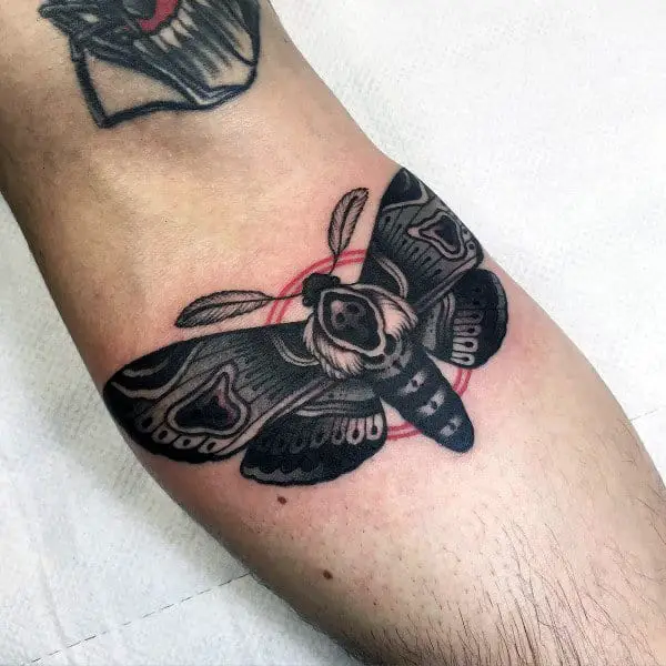 black-moth-with-red-circle-mens-inner-forearm-tattoos