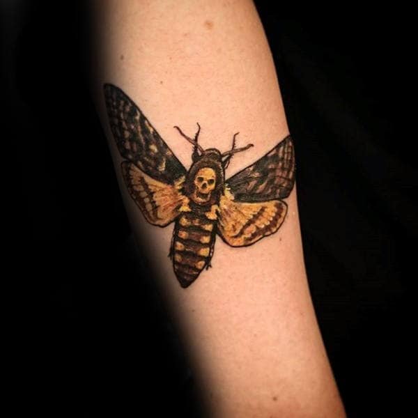 man-with-tattoo-of-black-and-yellow-moth-on-forearm