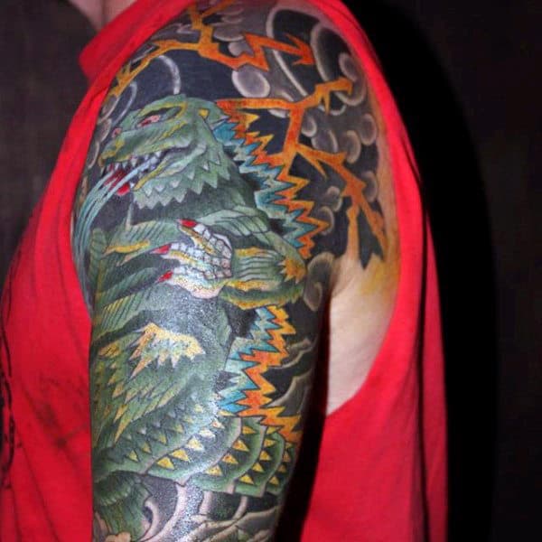 black-and-colorful-tattoo-of-godzilla-fighting-mans-sleeve