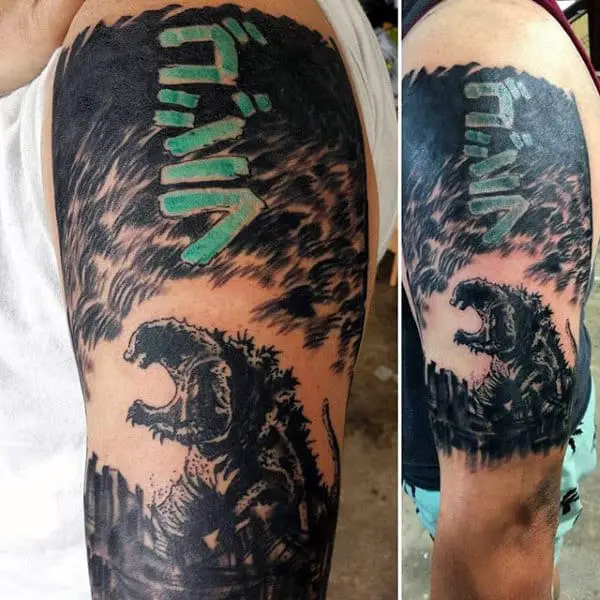 black-tattoo-with-color-godzilla-japanese-script-on-mans-bicep