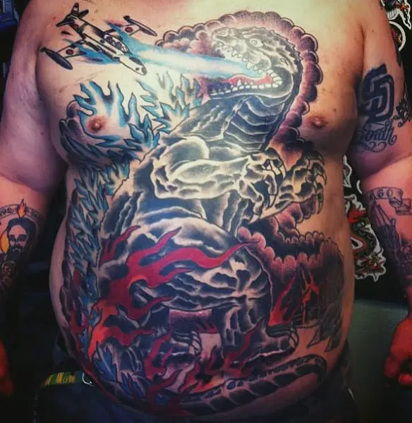 large-stomach-tattoo-of-godzilla-in-water-and-plane-on-man