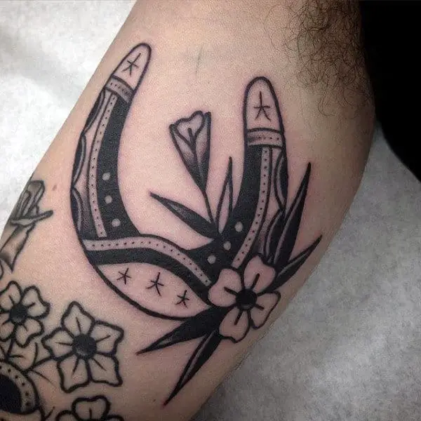 black-ink-traditional-guys-horseshoe-with-flower-tattoo-design-on-bicep