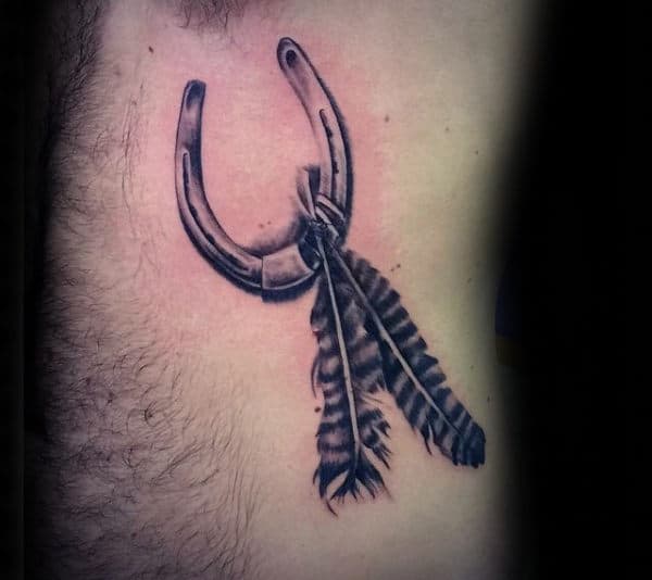 horseshoe-with-feathers-mens-rib-cage-side-of-body-tattoo