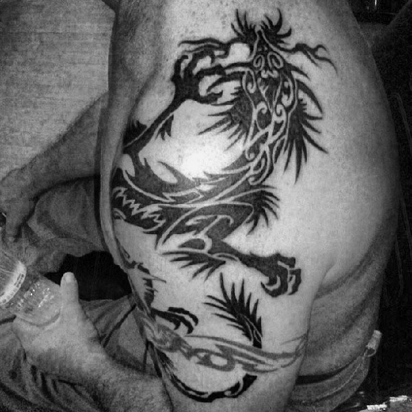 man-with-tribal-dragon-tattoos-arm