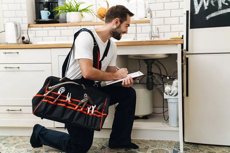 Image of plumber man with equipment and clipboard working in apa