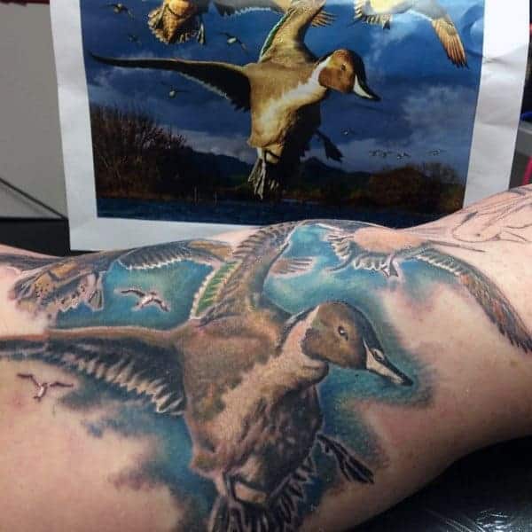 flying-ducks-over-blue-sky-tattoo-on-guy