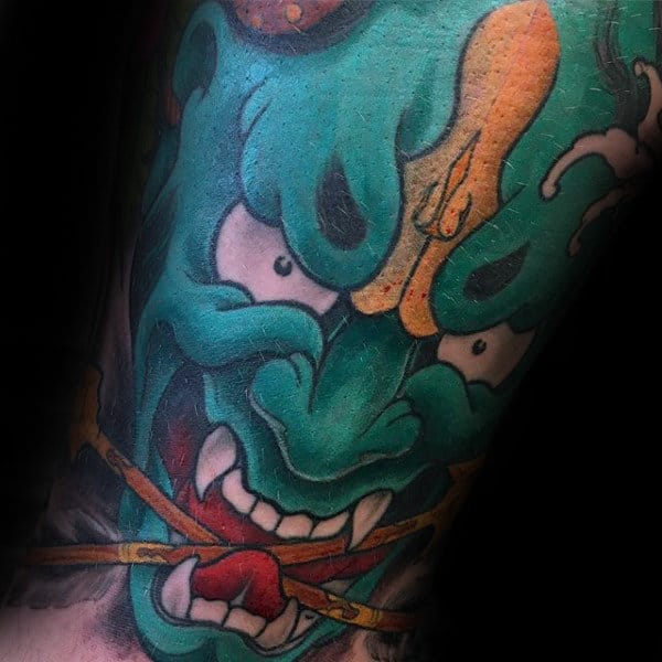 green-hannya-mask-with-arrows-in-mouth-male-tattoo-on-arm