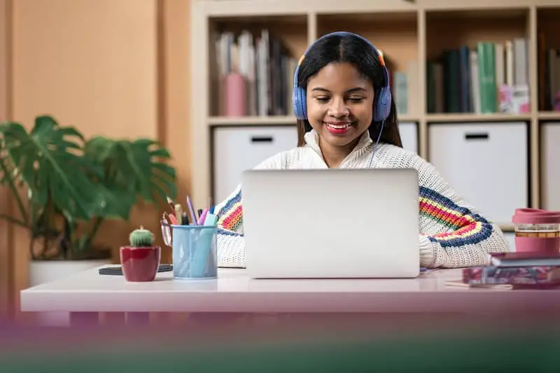 Teenager African American Female Student studying and working at home with laptop