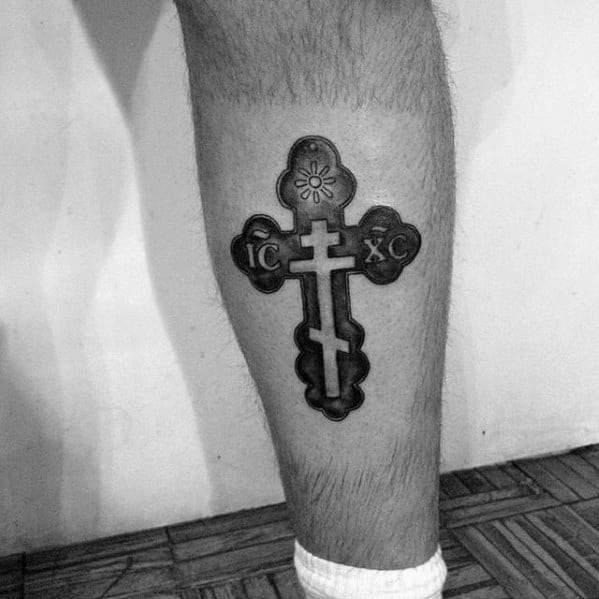 negative-space-small-religious-cross-mens-leg-calf-tattoo