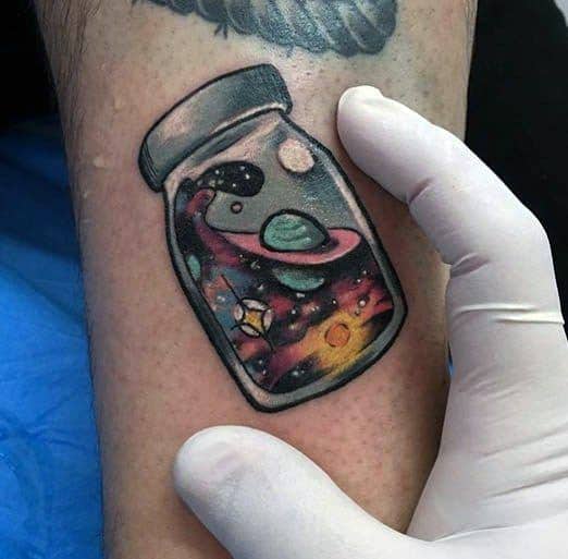 glass-with-outer-space-night-sky-guys-small-colorful-arm-tattoo
