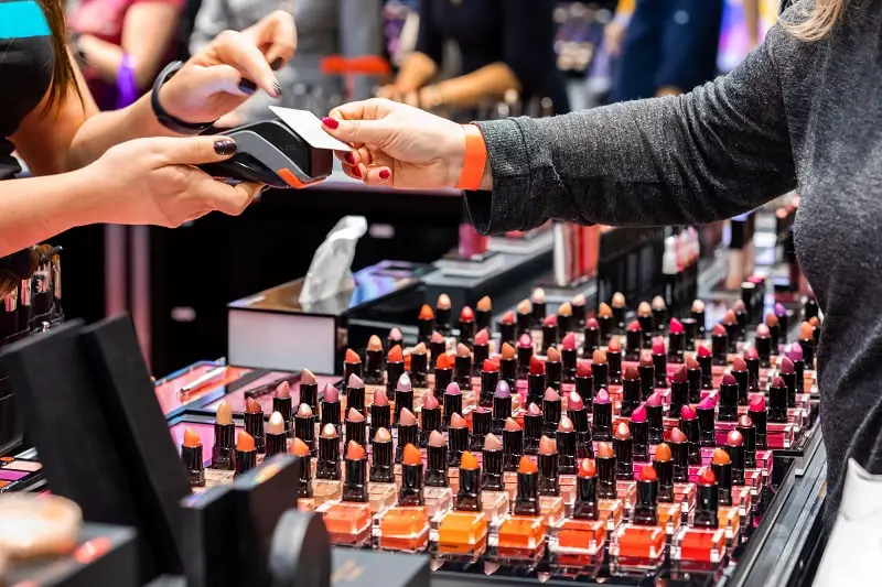 Customer woman paying for a products using credit card in beauty store