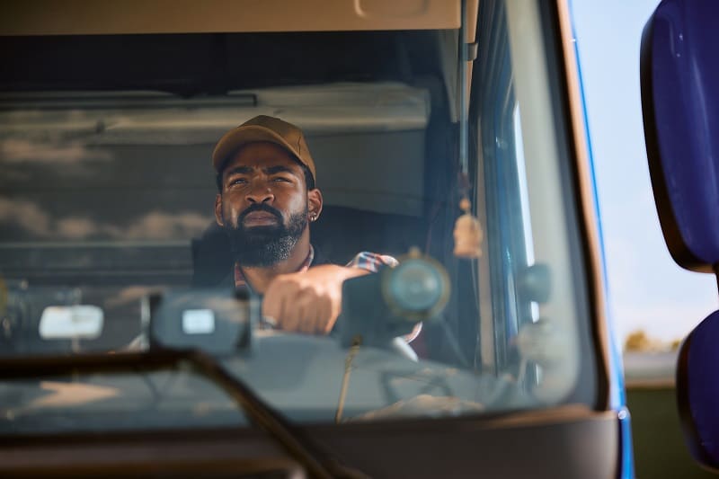 Professional black driver driving a truck.