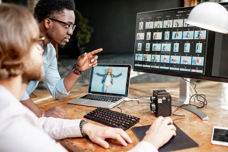 Two photographers working on the computers in the studio